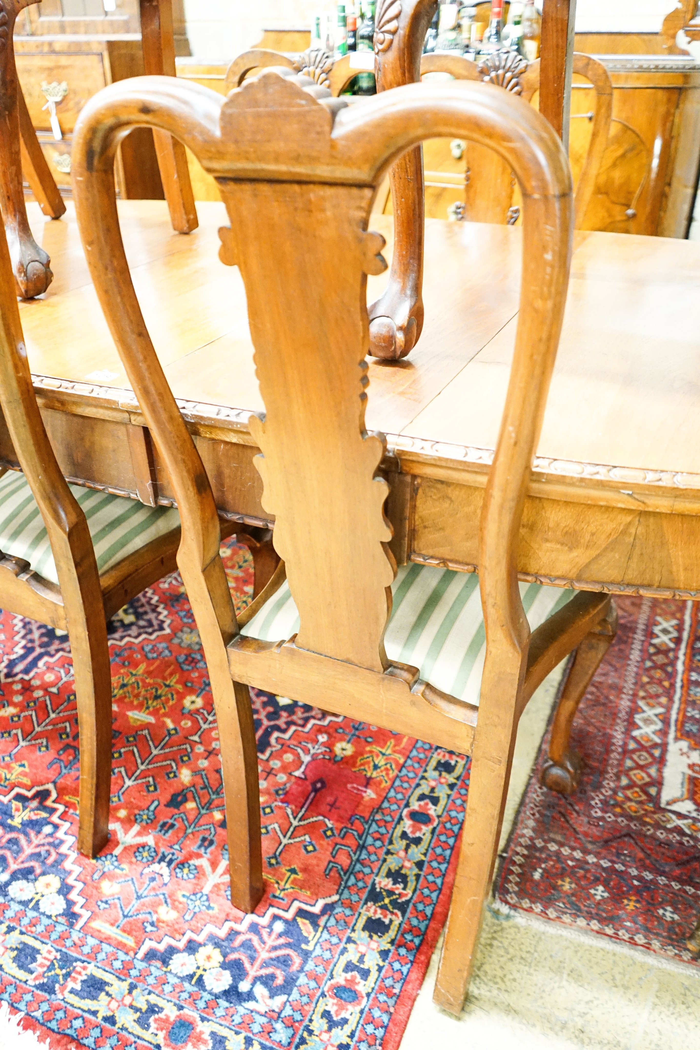 A Queen Anne style figured walnut dining suite comprising extending dining table, 200cm extended (one spare leaf), width 104cm, height 76cm, six chairs (two with arms) and a concave fronted sideboard